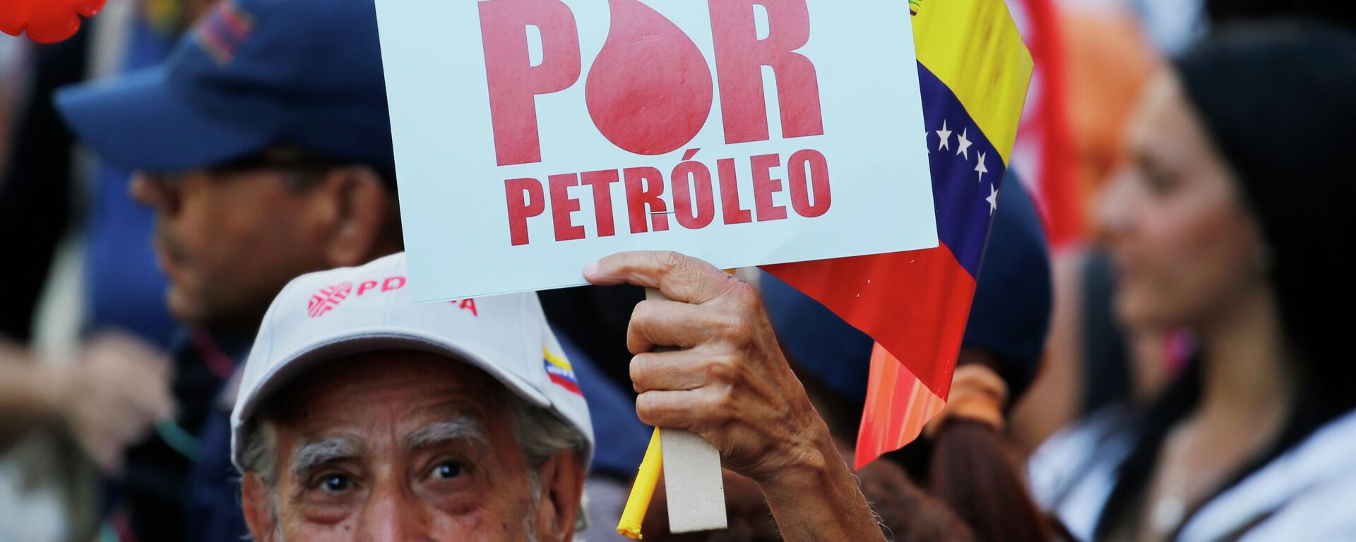 Manifestante segura placa com os dizeres em espanhol Eles atacam por petróleo, durante marcha convocada pelo governo em apoio à estatal petrolífera PDVSA, em Caracas. Venezuela, 31 de janeiro de 2019 - Sputnik Brasil, 1920, 10.11.2025