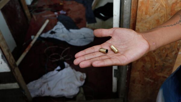 Homem mostra cápsulas de balas no local onde criança foi morta por bala perdida durante operação policial na favela Nova Jerusalém. Rio de Janeiro (RJ), Brasil, 14 de fevereiro de 2019 - Sputnik Brasil