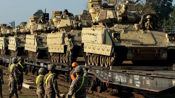 Membros do 1º Batalhão Blindado do 9º Regimento, 1ª Divisão do Exército dos EUA, de Fort Hood, Texas, se preparam para descarregar veículos de combate de infantaria Bradley de vagões ferroviários à estação ferroviária de Pabrade, a cerca de 50 km ao norte da capital Vilnius, Lituânia, 21 de outubro de 2019 - Sputnik Brasil