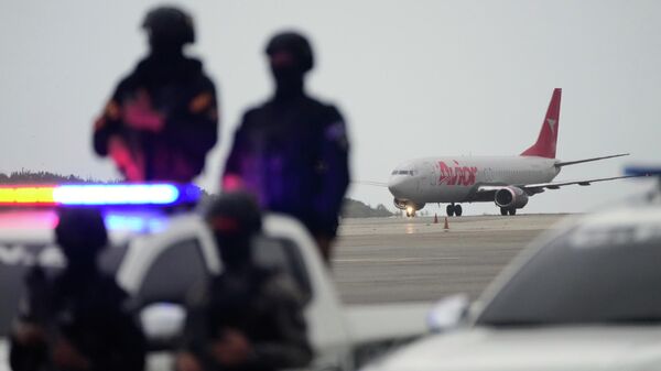 Forças policiais próximo a avião que levava venezuelanos deportados dos Estados Unidos de volta ao país, 18 de julho de 2025 - Sputnik Brasil