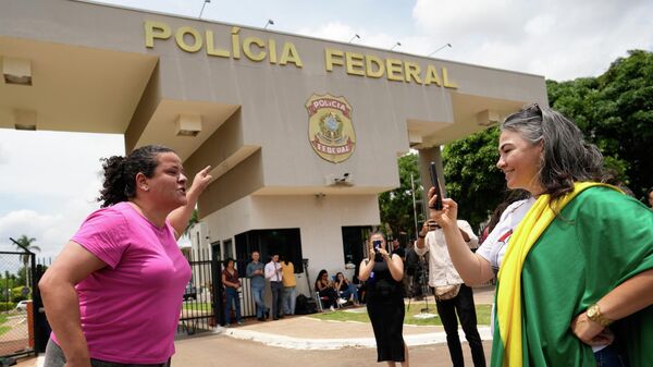Apoiadores e oponentes do ex-presidente Jair Bolsonaro discutem diante da Superintendência da Polícia Federal, onde o ex-presidente está preso - Sputnik Brasil