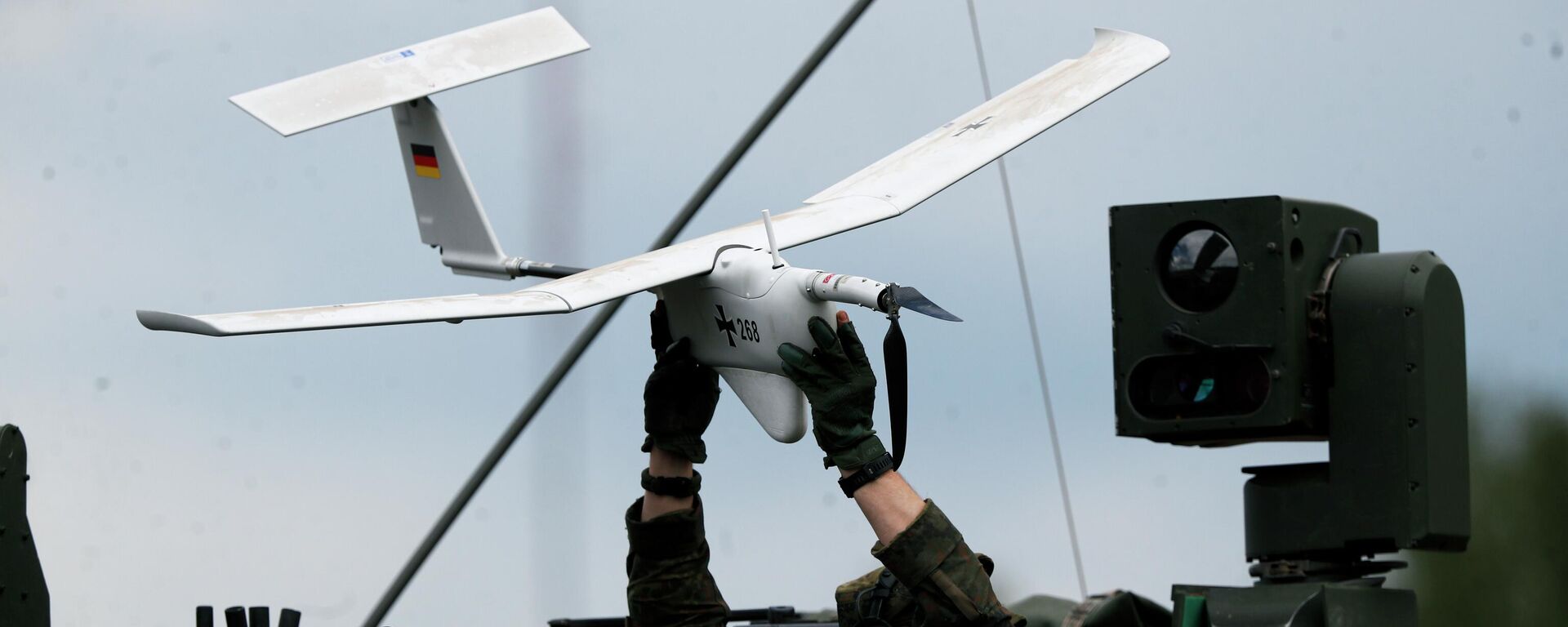 Soldado segura drone dentro de um veículo militar da Organização do Tratado do Atlântico Norte (OTAN) em movimento, durante um exercício militar no campo de treinamento em Pabrade, a cerca de 60 quilômetros ao norte da capital da Lituânia, Vilnius, em 26 de junho de 2023 - Sputnik Brasil, 1920, 19.03.2026