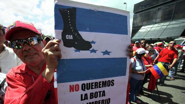 Apoiador do presidente venezuelano Hugo Chávez segura um cartaz com os dizeres em espanhol Não queremos a bota do império na América Latina durante um protesto em Caracas. Venezuela, 13 de novembro de 2009 - Sputnik Brasil