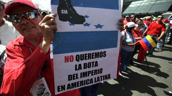 Apoiador do presidente venezuelano Hugo Chávez segura um cartaz com os dizeres em espanhol Não queremos a bota do império na América Latina durante um protesto em Caracas. Venezuela, 13 de novembro de 2009 - Sputnik Brasil