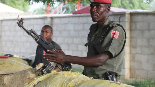 Policiais armados com fuzis AK-47 fazem guarda em bunkers protegidos com sacos de areia ao longo de uma importante estrada em Maiduguri, Nigéria, em setembro de 2011 - Sputnik Brasil