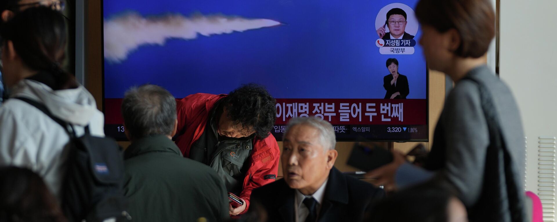 Uma tela de TV exibe uma reportagem sobre os mísseis balísticos da Coreia do Norte com imagens de arquivo durante um programa de notícias na Estação Ferroviária de Seul, em Seul, Coreia do Sul, 7 de novembro de 2025 - Sputnik Brasil, 1920, 10.12.2025