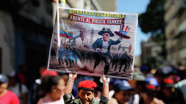 Boneco representando Hugo Chávez segura uma placa com a imagem de Donald Trump como um pirata e a mensagem em espanhol: Em defesa da soberania contra o pirata ianque, em protesto contra a intervenção dos EUA, em Caracas. Venezuela, 13 de dezembro de 2025 - Sputnik Brasil