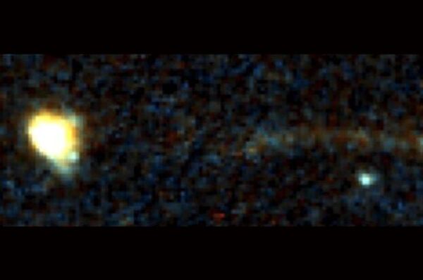 Uma estranha faixa emergindo de uma galáxia distante. A galáxia está à esquerda; a faixa atinge seu brilho máximo na distância mais longínqua da galáxia - Sputnik Brasil