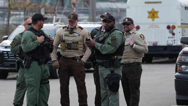 Agentes da lei fazem a segurança da entrada de um centro de detenção do ICE em Chicago, nos EUA, em novembro de 2025 - Sputnik Brasil