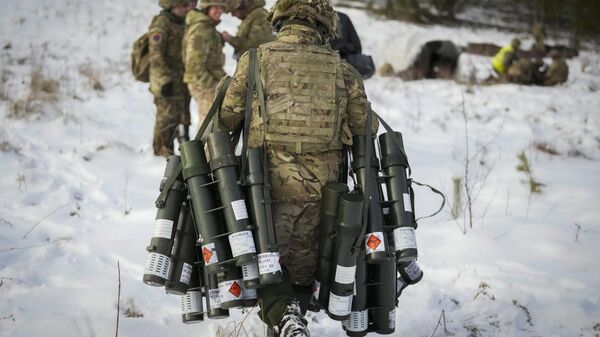 Um soldado britânico carrega tubos vazios de morteiros durante os exercícios militares do Campo de Inverno 23, perto de Tapa, na Estônia, em fevereiro de 2023 - Sputnik Brasil