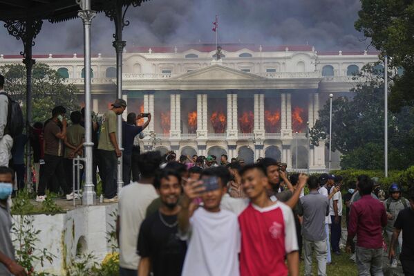 Protestos da geração Z no NepalOs manifestantes tiram fotos em frente ao palácio Singha Durbar, sede do governo nepalês em Katmandu, após o prédio ter sido incendiado durante os protestos contra a corrupção e banimento das redes sociais, 9 de setembro. - Sputnik Brasil