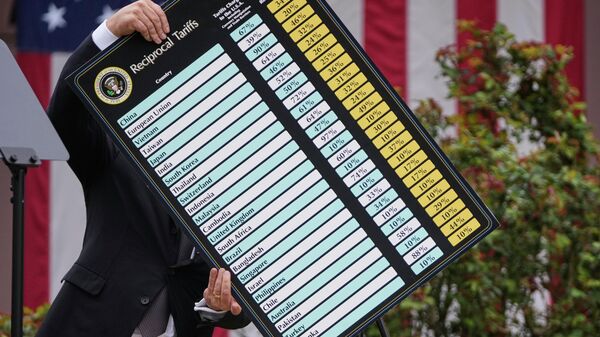 O secretário de Comércio dos EUA, Howard Lutnick, leva uma placa durante o discurso de Donald Trump quando ele anunciava as novas tarifas na Casa Branca, 2 de abril. - Sputnik Brasil