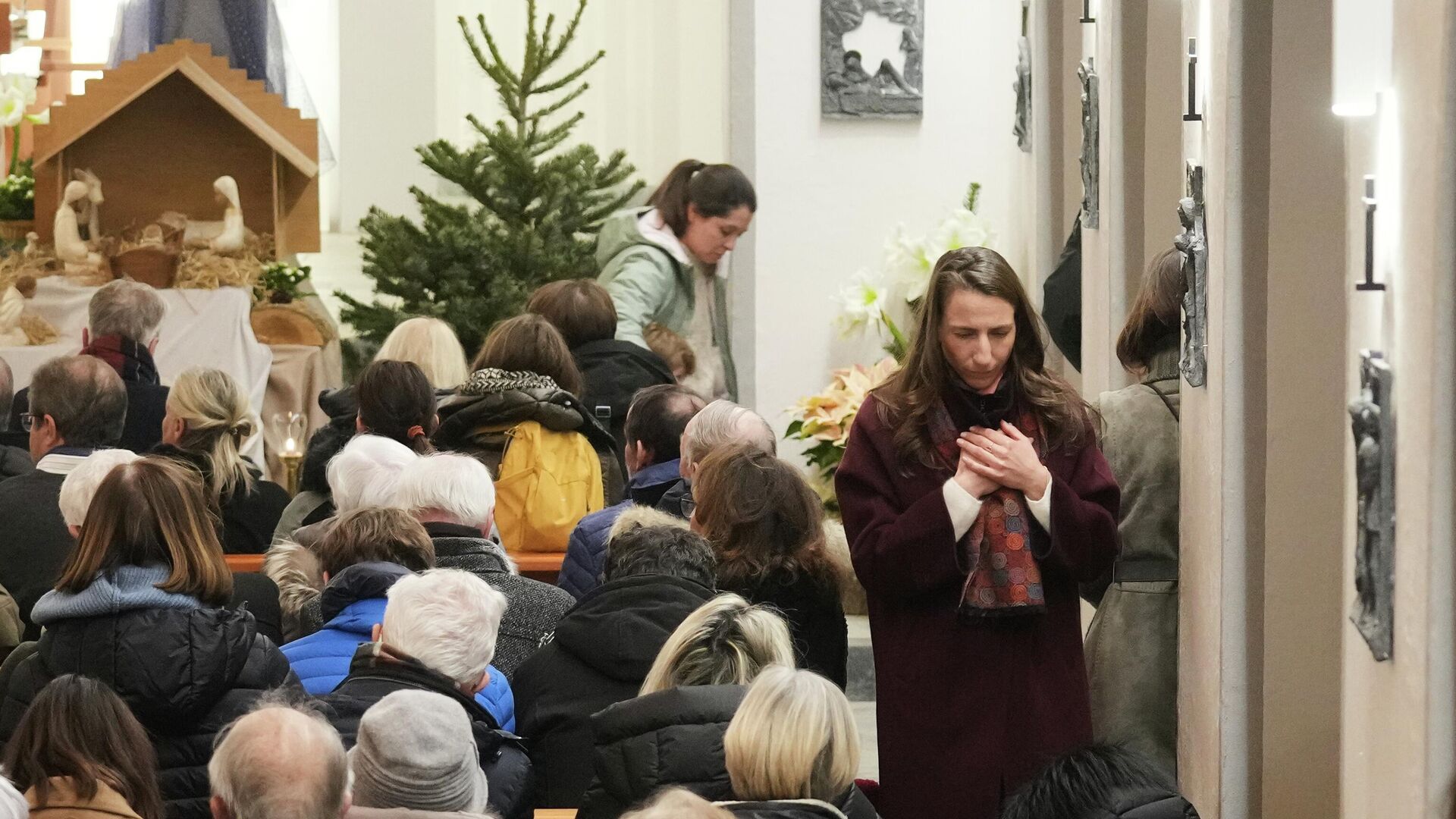 Pessoas participam de uma missa de Ano Novo na igreja católica de Crans-Montana para homenagear as vítimas do incêndio. - Sputnik Brasil, 1920, 01.01.2026