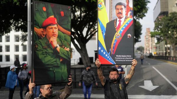 Apoiadores do governo da Venezuela mostram com as fotos de Hugo Chávez e o presidente Nicolás Maduro, sequestrado pelos Estados Unidos - Sputnik Brasil