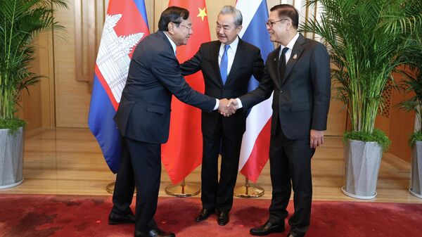 Nesta foto divulgada pela Agence Kampuchea Press (AKP), o ministro das Relações Exteriores do Camboja, Prak Sokhonn (E), cumprimenta seu homólogo tailandês, Sihasak Phuangketkeow (D), diante do seu homólogo chinês, Wang Yi, na província de Yunnan, China, 29 de dezembro de 2025. - Sputnik Brasil