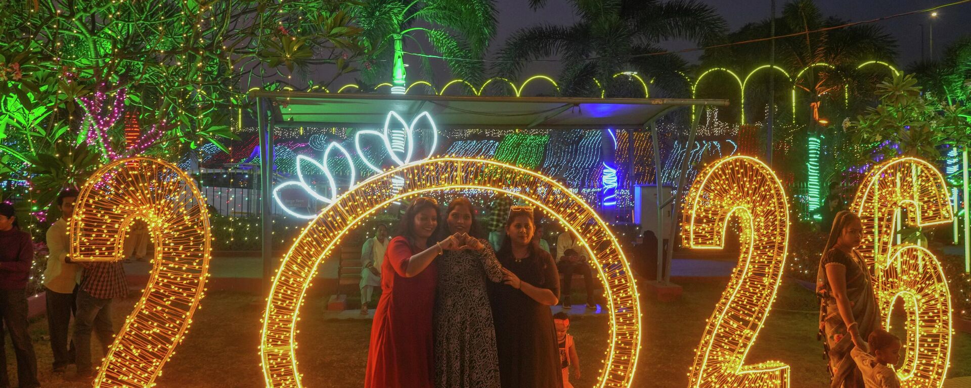 Pessoas posam para fotos perto de decorações iluminadas na véspera de Ano Novo em Mumbai, Índia, quarta-feira, 31 de dezembro de 2025. - Sputnik Brasil, 1920, 06.01.2026