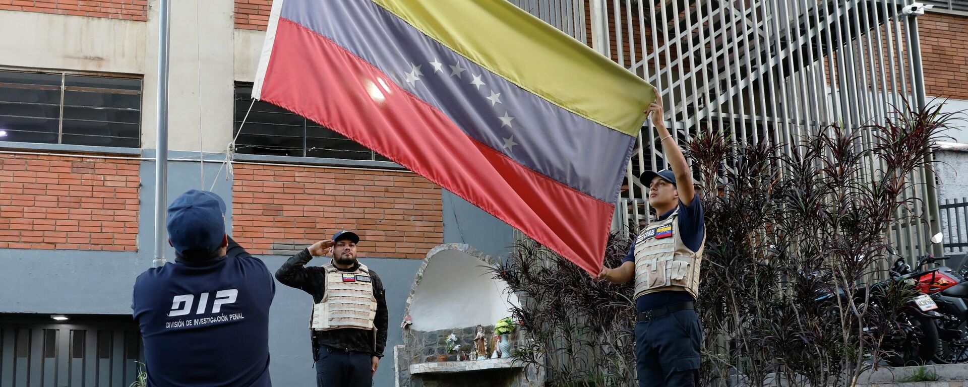 Policiais venezuelanos hasteiam bandeira do país, em Caracas, capital do país, em janeiro de 2026 - Sputnik Brasil, 1920, 09.01.2026