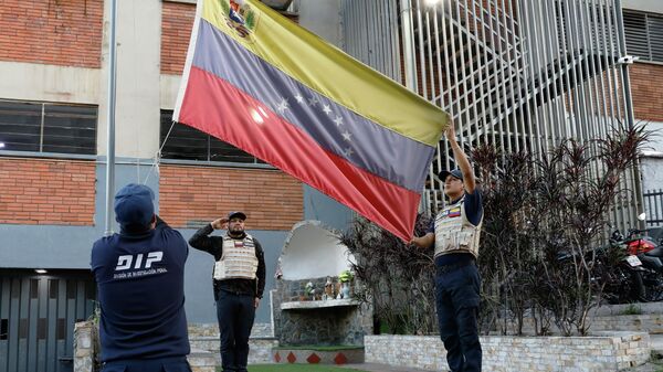 Policiais venezuelanos hasteiam bandeira do país, em Caracas, capital do país, em janeiro de 2026 - Sputnik Brasil