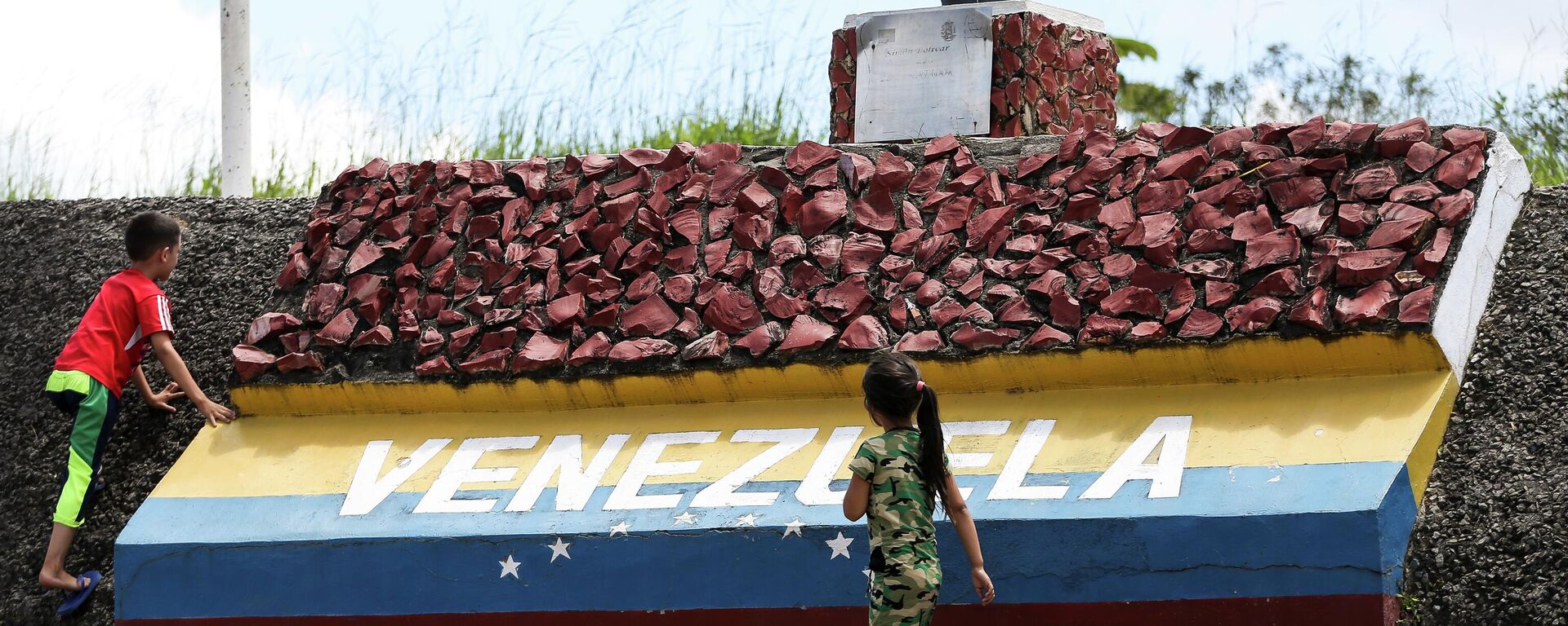 Crianças brincam em marco da fronteira entre Brasil e Venezuela, Roraima, 22 de agosto de 2018 - Sputnik Brasil, 1920, 11.01.2026