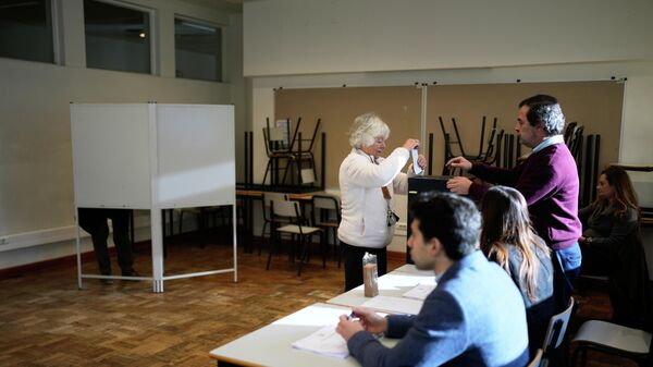 Mulher vota nas eleições presidenciais de Portugal em uma seção eleitoral em Lisboa, domingo, 18 de janeiro de 2026. - Sputnik Brasil