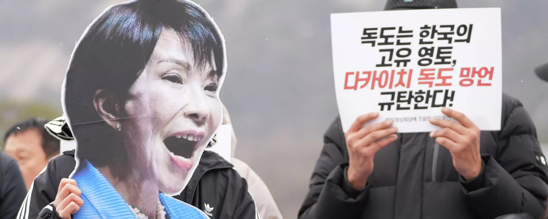 Manifestante segura foto da primeira-ministra japonesa Sanae Takaichi ao lado de um cartaz que diz Dokdo é território da Coreia do Sul e Denunciem o comentário de Takaichi sobre Dokdo durante um protesto antes da cúpula entre a Coreia do Sul e o Japão, em Seul, Coreia do Sul, 12 de janeiro de 2026. - Sputnik Brasil, 1920, 21.01.2026