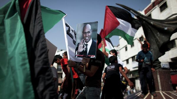 Um menino palestino segura um cartaz de Saif al-Islam Kadhafi, filho do líder líbio Muammar Kadhafi, durante uma manifestação em apoio a um navio líbio que se dirige para Gaza, na mais recente tentativa de frustrar o bloqueio naval israelense, na Cidade de Gaza, segunda-feira, 12 de julho de 2010. - Sputnik Brasil