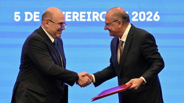 O primeiro-ministro da Rússia, Mikhail Mishustin (à esq.), cumprimenta o vice-presidente do Brasil, Geraldo Alckmin (à dir.), durante evento em Brasília, em fevereiro de 2026 - Sputnik Brasil