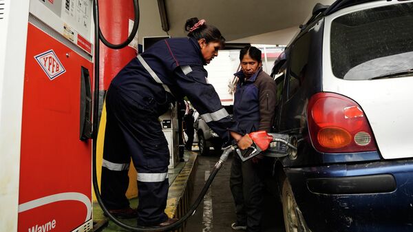 Motorista observa frentista abastecendo veículo em La Paz, na Bolívia, em dezembro de 2025 - Sputnik Brasil