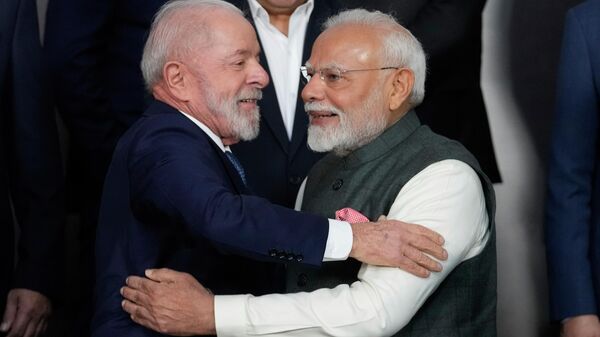 O presidente brasileiro Luiz Inácio Lula da Silva (E), cumprimenta o primeiro-ministro indiano Narendra Modi antes de uma foto de grupo durante a 17ª cúpula anual do BRICS no Rio de Janeiro, 7 de julho de 2025 - Sputnik Brasil