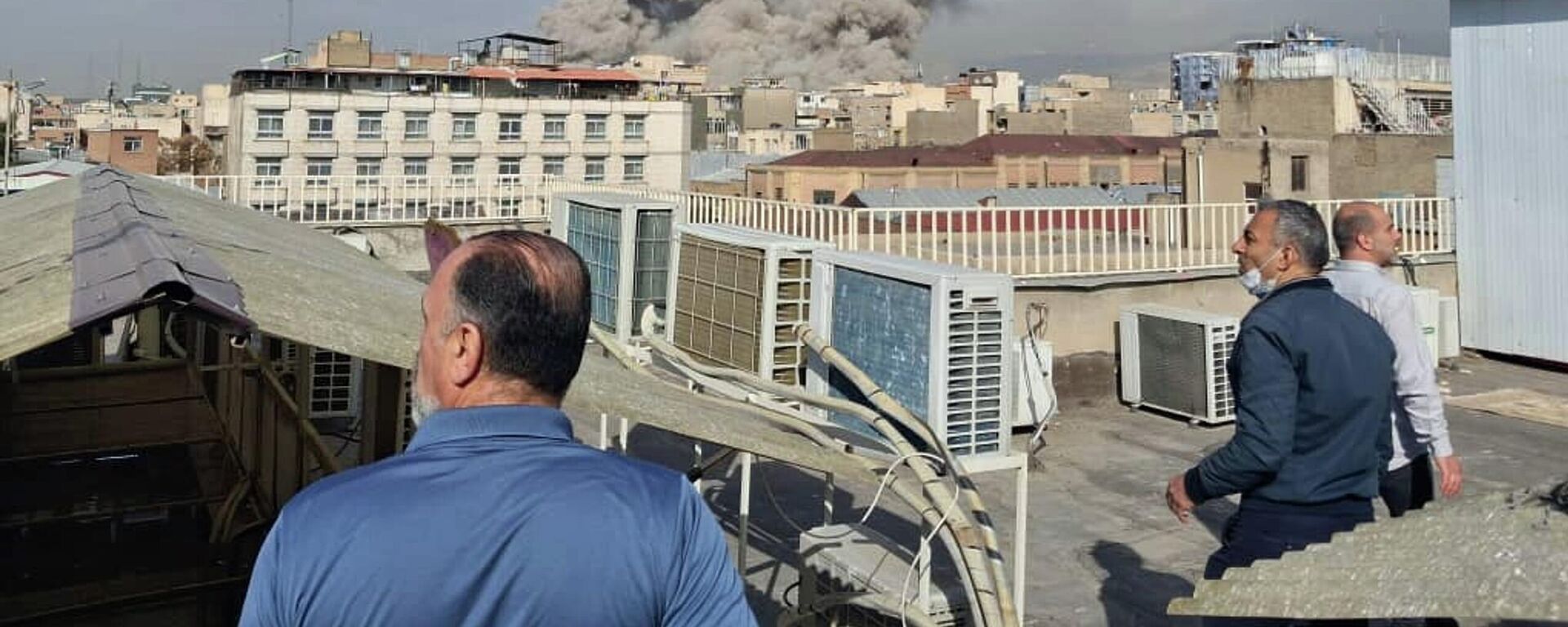 Pessoas observando a fumaça subindo acima do horizonte após a explosão em Teerã, Irã - Sputnik Brasil, 1920, 28.02.2026