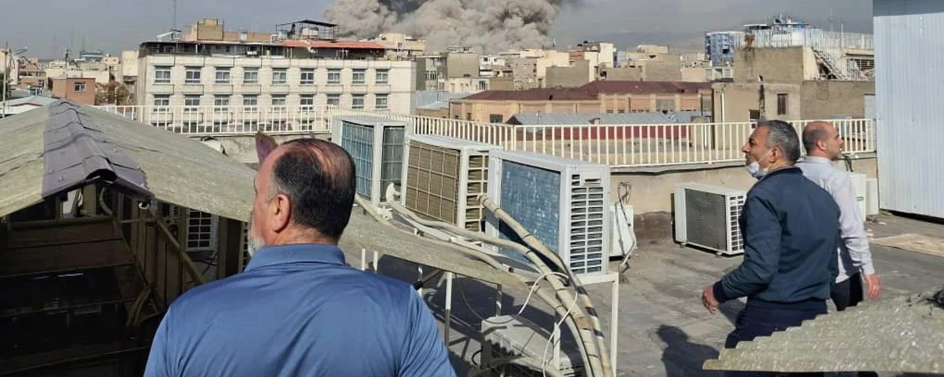 Pessoas observando a fumaça subindo acima do horizonte após a explosão em Teerã, Irã - Sputnik Brasil, 1920, 21.03.2026