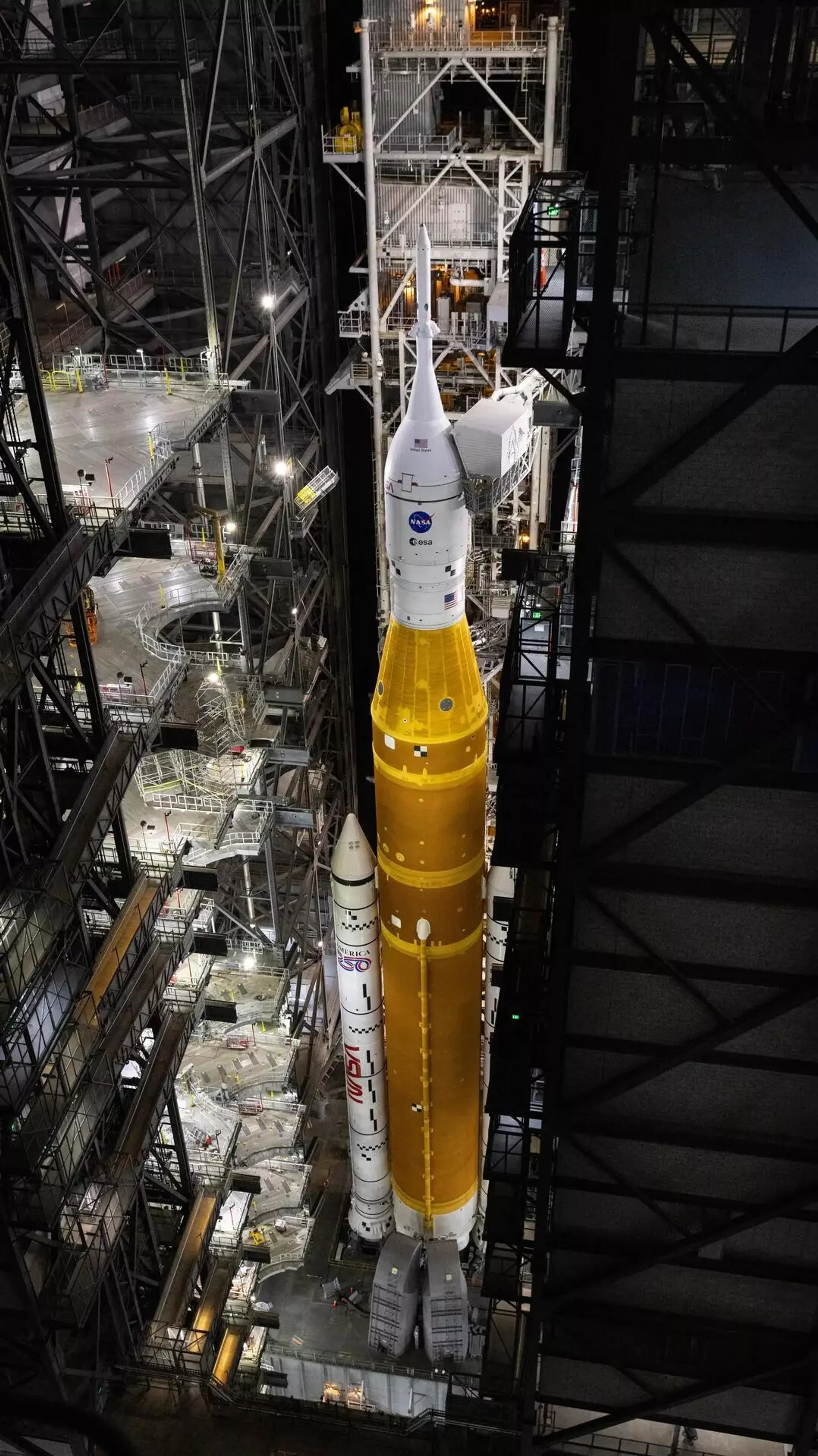 O veículo de transporte sobre esteiras 2 da NASA, que carrega o foguete Artemis II SLS com a espaçonave Orion, chega ao Edifício de Montagem de Veículos no Centro Espacial Kennedy da NASA, na Flórida, para solucionar problemas no fluxo de hélio para o estágio superior do foguete, o estágio de propulsão criogênica intermediário, 25 de fevereiro de 2026 - Sputnik Brasil, 1920, 03.03.2026