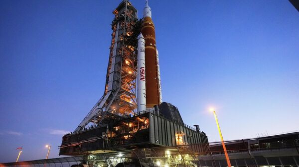 O foguete Artemis II do Sistema de Lançamento Espacial (SLS, na sigla em inglês) da NASA, com a espaçonave Orion a bordo, retorna lentamente em direção ao Edifício de Montagem de Veículos no Centro Espacial Kennedy, em Cabo Canaveral, Flórida, 25 de fevereiro de 2026 - Sputnik Brasil