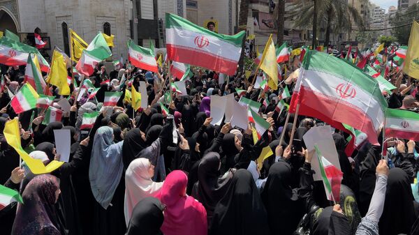 Apoiadores do Hezbollah agitam bandeiras do grupo e do Irã durante um protesto contra os ataques israelenses a várias cidades do Irã, no subúrbio sul de Beirute, Líbano, 20 de junho de 2025 - Sputnik Brasil