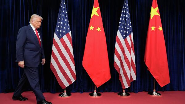 O presidente norte-americano Donald Trump caminha em frente às bandeiras dos EUA e da China para se encontrar com o presidente chinês Xi Jinping no Aeroporto Internacional de Gimhae, em Busan, Coreia do Sul, 30 de outubro de 2025 - Sputnik Brasil