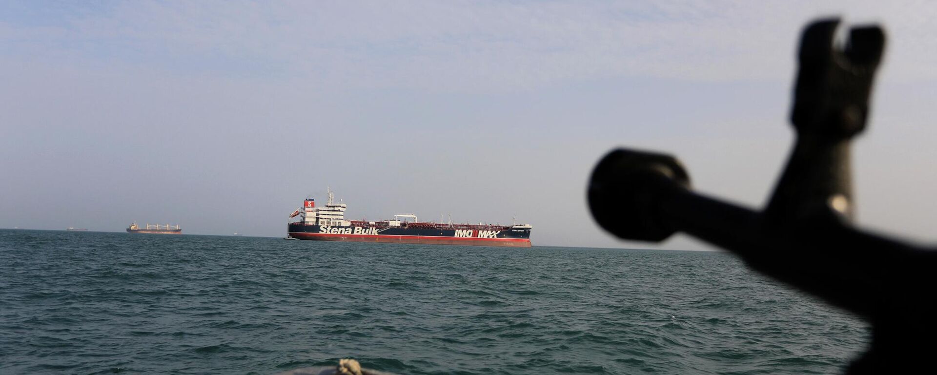Arquivo: uma lancha do Corpo de Guardiães da Revolução Islâmica (IRGC, na sigla em inglês) do Irã aponta uma arma para o petroleiro Stena Impero, de bandeira britânica, que foi apreendido no estreito de Ormuz, no porto iraniano de Bandar Abbas, 21 de julho de 2019 - Sputnik Brasil, 1920, 18.03.2026