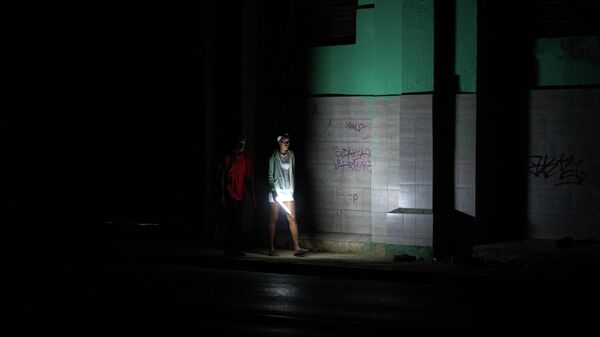 Pessoas caminham por uma rua durante um apagão em Havana, Cuba. - Sputnik Brasil