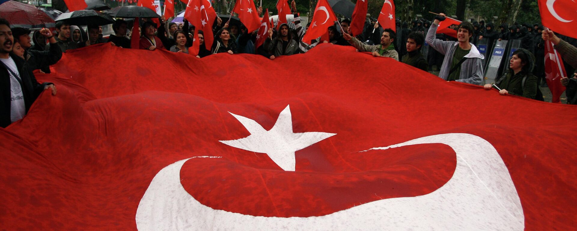 Protesto em Istambul, Turquia, com uma bandeira do país estendida. - Sputnik Brasil, 1920, 22.03.2026