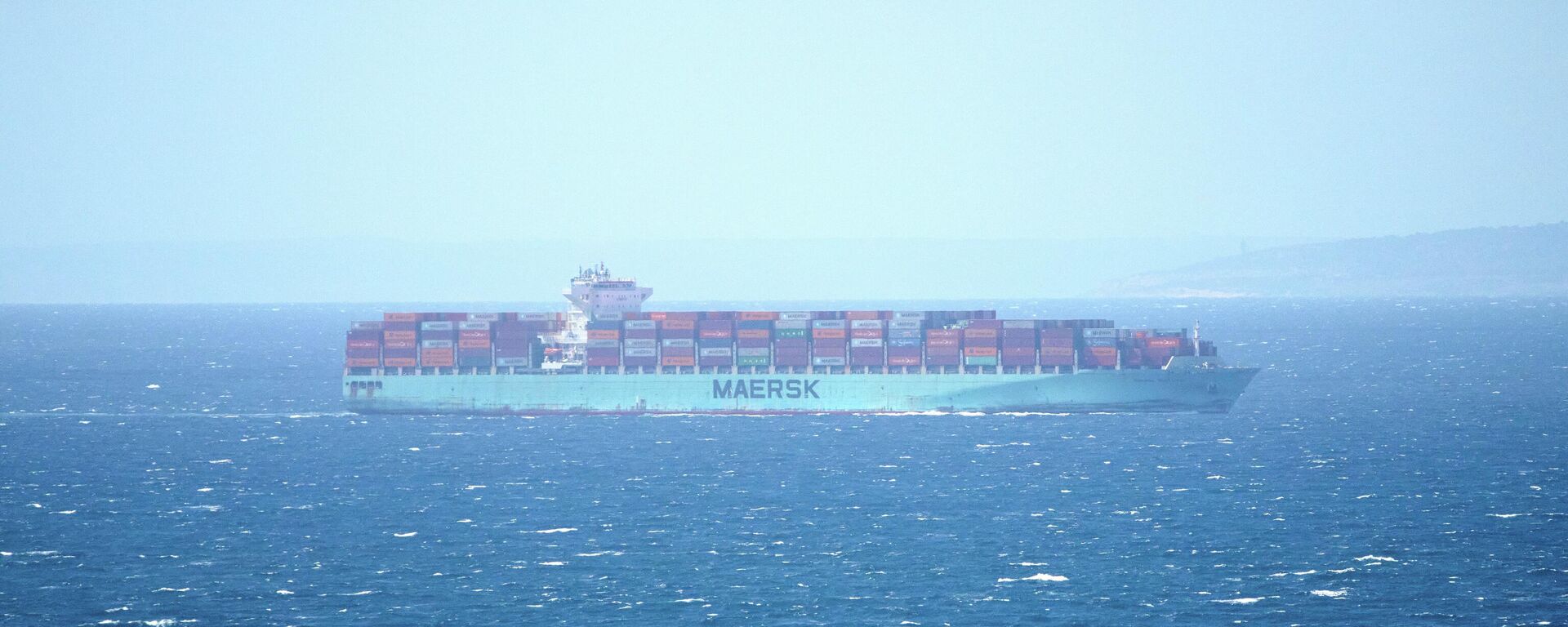 Navio cargueiro trafega próximo à costa do Marrocos pelo Estreito de Gibraltar, em abril de 2025. Ao fundo, o continente europeu - Sputnik Brasil, 1920, 22.04.2026
