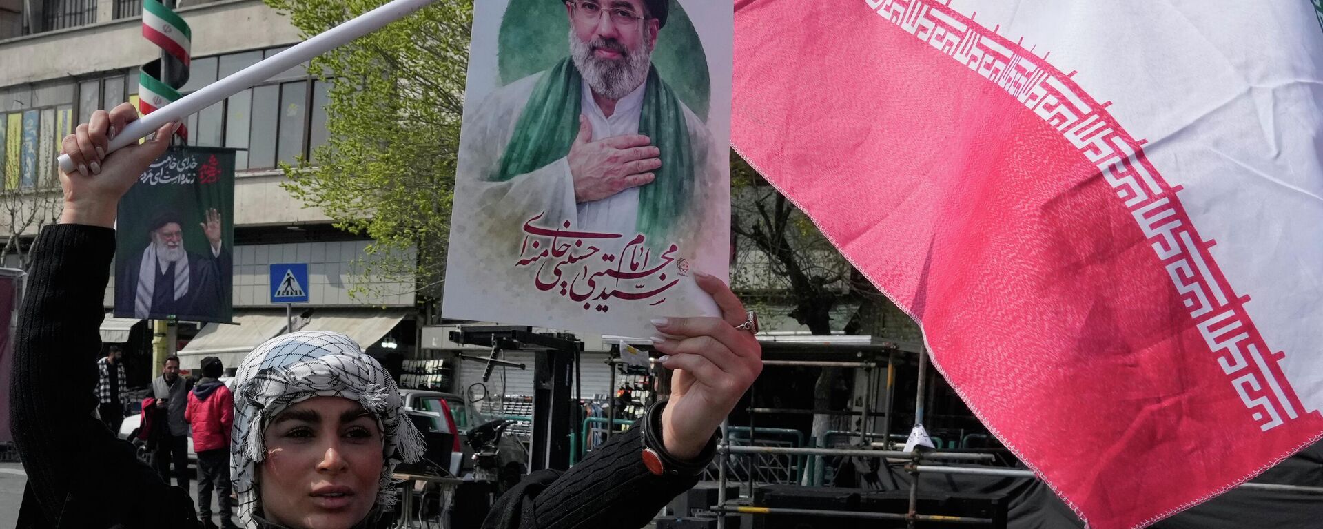 Mulher exibe um cartaz do líder supremo iraniano, o aiatolá Mojtaba Khamenei - Sputnik Brasil, 1920, 27.03.2026