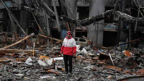 Membro do Crescente Vermelho Iraniano inspeciona os escombros de uma oficina mecânica em em Teerã após um ataque dos EUA e Israel, Irã, 28 de março de 2026 - Sputnik Brasil