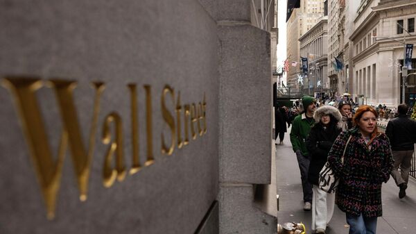 Pessoas caminham em frente a uma placa de Wall Street do lado de fora da Bolsa de Valores de Nova York, 11 de dezembro de 2023 - Sputnik Brasil