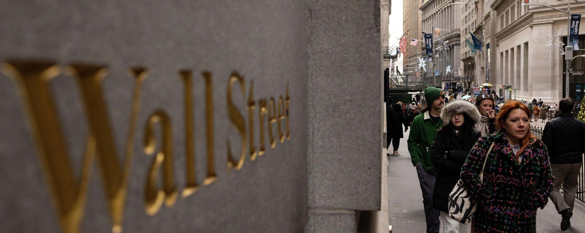 Pessoas caminham em frente a uma placa de Wall Street do lado de fora da Bolsa de Valores de Nova York, 11 de dezembro de 2023 - Sputnik Brasil, 1920, 31.03.2026