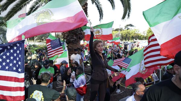 Participantes agitam bandeiras durante uma manifestação contra a guerra com o Irã em Los Angeles, 7 de março de 2026 - Sputnik Brasil