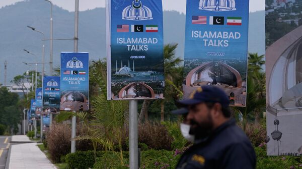 Agentes de segurança estão posicionados ao lado de cartazes referentes às negociações entre os Estados Unidos e o Irã, em frente a um centro de apoio à imprensa em Islamabad, Paquistão, 11 de abril de 2026 - Sputnik Brasil