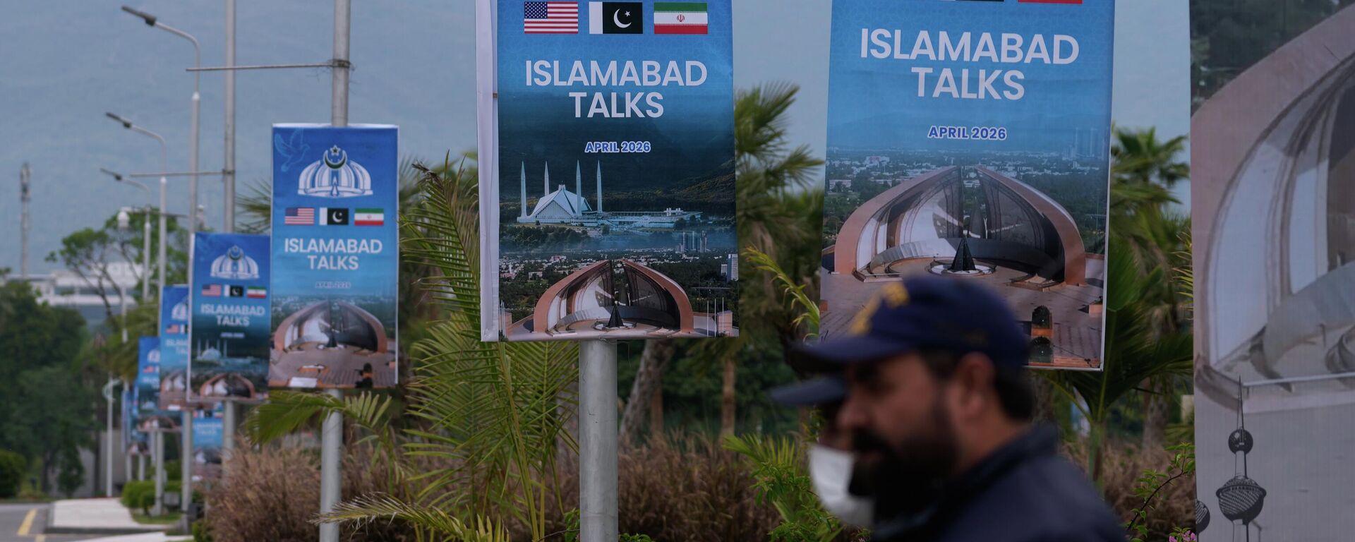 Agentes de segurança estão posicionados ao lado de cartazes referentes às negociações entre os Estados Unidos e o Irã, em frente a um centro de apoio à imprensa em Islamabad, Paquistão, 11 de abril de 2026 - Sputnik Brasil, 1920, 11.04.2026
