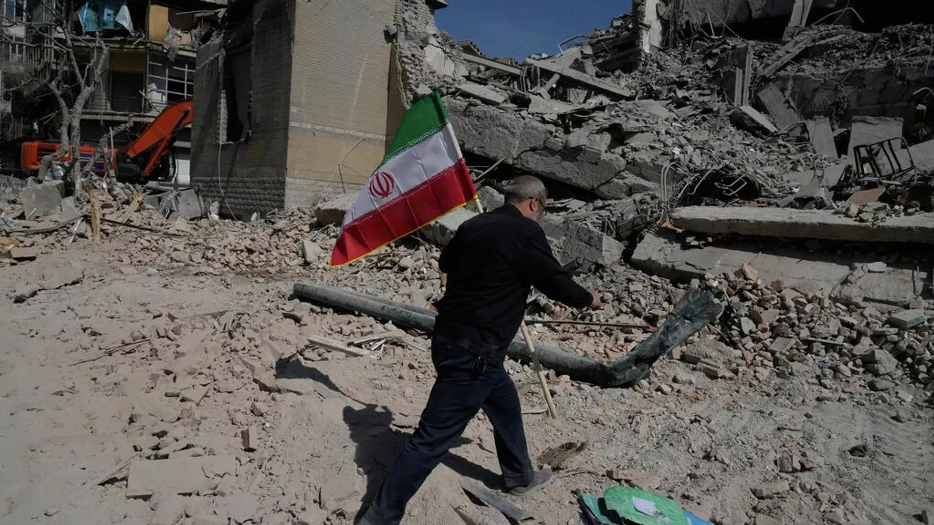 Um homem carrega uma bandeira iraniana para colocá-la sobre os escombros de uma instalação policial atingida durante a campanha militar conjunta dos EUA e de Israel em Teerã, Irã, 4 de março de 2026 - Sputnik Brasil, 1920, 25.05.2026