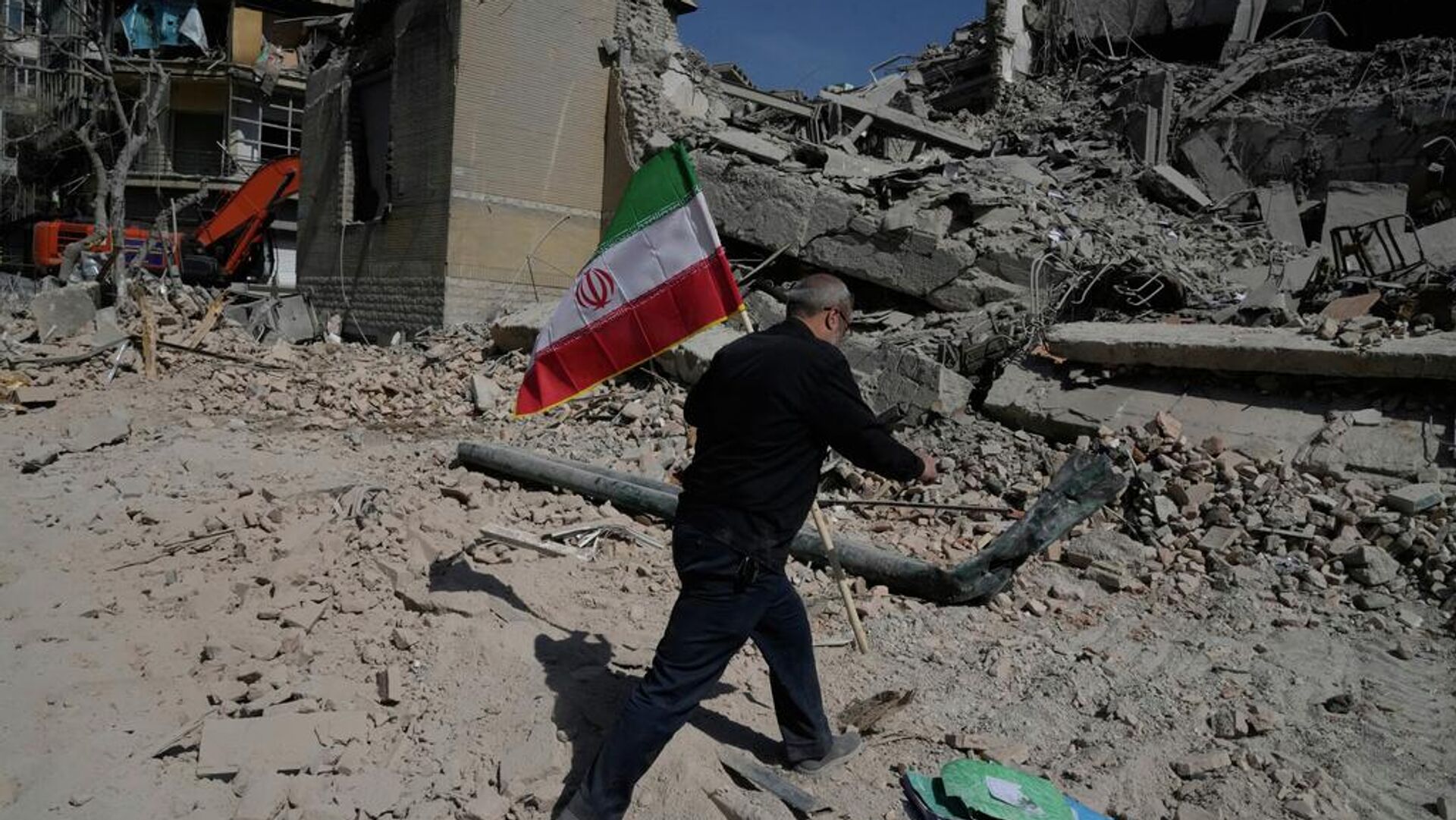 Um homem carrega uma bandeira iraniana para colocá-la sobre os escombros de uma instalação policial atingida durante a campanha militar conjunta dos EUA e de Israel em Teerã, Irã, 4 de março de 2026 Um homem carrega uma bandeira iraniana para colocá-la sobre os escombros de uma instalação policial atingida durante a campanha militar conjunta dos EUA e de Israel em Teerã, Irã, 4 de março de 2026 - Sputnik Brasil, 1920, 14.04.2026