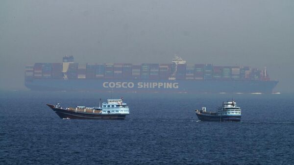 Dois dhows tradicionais navegam ao lado de um grande navio porta-contentores no estreito de Ormuz, 19 de maio de 2023 - Sputnik Brasil