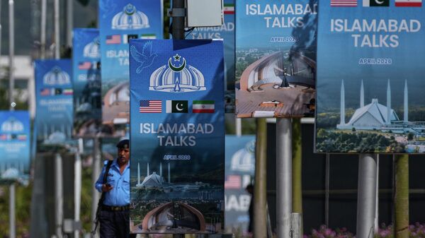 Um policial caminha ao lado de outdoors perto do Hotel Serena, em Islamabad, onde ocorrerá a segunda rodada de negociações entre os EUA e o Irã. Paquistão, 21 de abril de 2026 - Sputnik Brasil